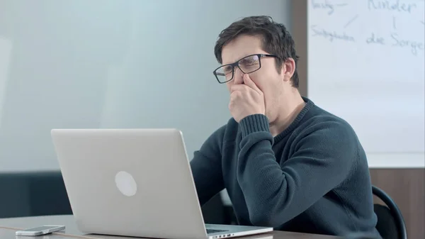 Estudiante cansado pensando en su trabajo y usando laptop — Foto de Stock