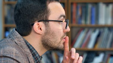 Deli genç öğretmenin yan görünüm profil portre Shhh ile dudaklara parmaklar yerleştirerek