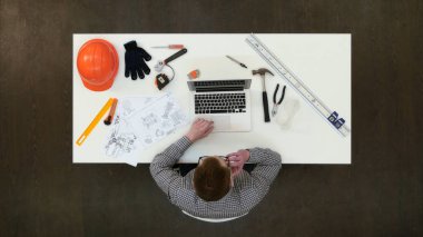 Dizüstü bilgisayarda çalışan ve telefon görüşmesi cevap ofiste mimar