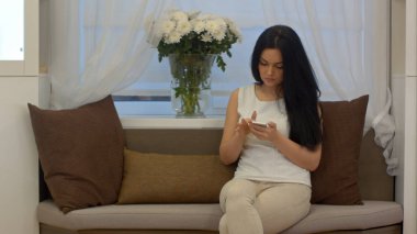 Cep telefonunuzda evde koltukta oturan genç işkadını sohbet ve manifatura ileti