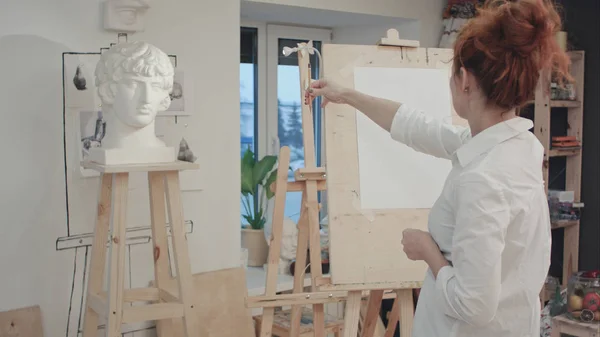 Mujer artista dibujo yeso busto en el taller — Foto de Stock