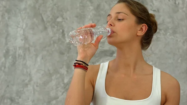 Портрет молодої красивої жінки, що п'є воду після занять з йоги — стокове фото