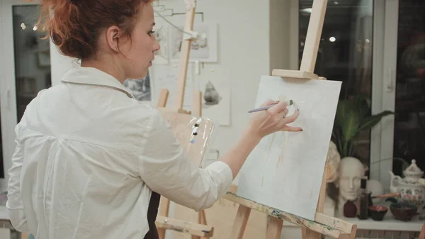 Pintor feminino desenho no estúdio de arte usando cavalete . — Fotografia de Stock