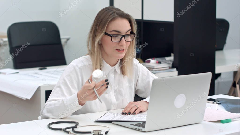 Female medicine doctor prescribing medicine using laptop