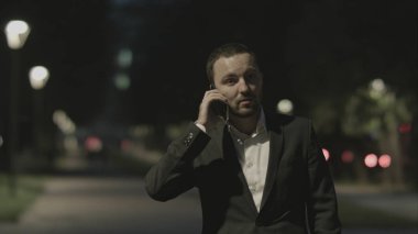 İyi bir ruh hali içinde şehir parkında telefonla konuşan işadamı dostu.