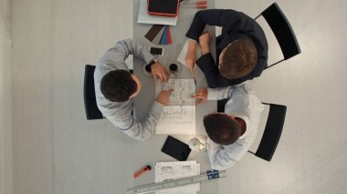 İnşaat binasında plan yapan Mimarlar. İnşaat, Mimarlık, iş, ekip çalışması ve insan konsepti. Üst görünüm