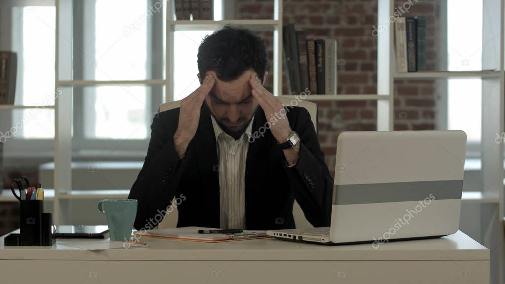 Depressed businessman sitting at computer