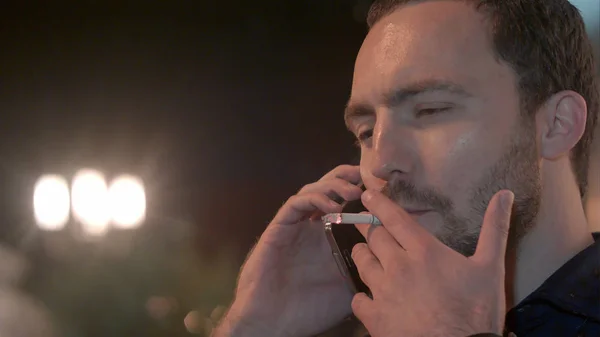 Muž kouří a volá telefonem — Stock fotografie