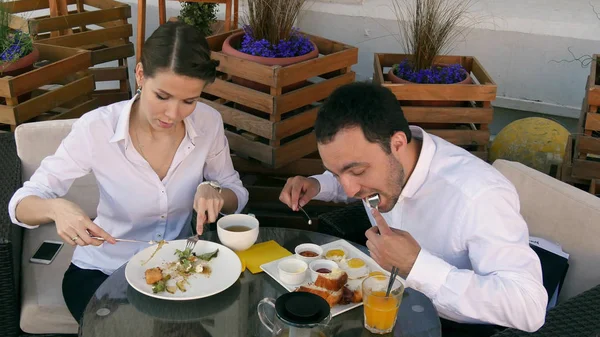 Joven empresario guapo comiendo con su pareja en el restaurante —  Fotos de Stock