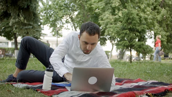 Giovane dirigente che lavora nel parco sul computer portatile, mentre pranza — Foto Stock