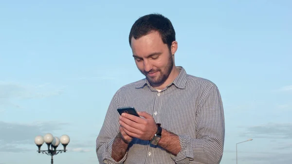 Чоловік тримає мобільний смартфон за допомогою текстового повідомлення програми — стокове фото