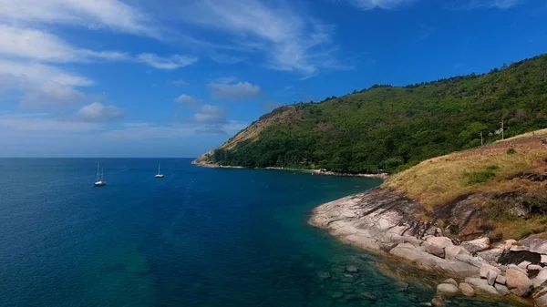 Copter aerial view of yacht moored in a bay near beach, where people are swimming and having sunbath — Stock Photo, Image