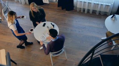 Bir çift için kahve servisi yapan garson. Üst görünüm. 4k çözünürlükte profesyonel çekim. 090. Eğer ticari video, iş, sunum, yayın video örneğin kullanabilirsiniz.