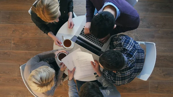 Grupo de gente de negocios confiada en ropa casual inteligente trabajando juntos mientras están sentados en el escritorio en la oficina — Foto de Stock