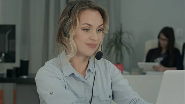 Operador de llamadas con auriculares usando portátil en el escritorio en el trabajo — Foto de Stock
