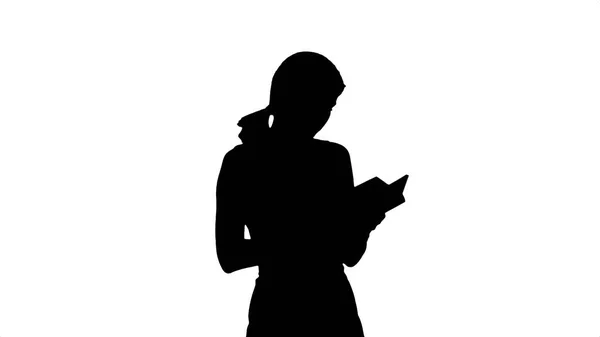 Silhouette junges Mädchen mit Buch auf Laptop — Stockfoto