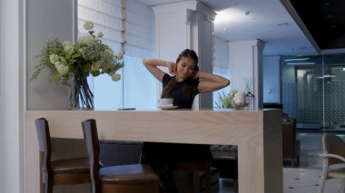 Telefonunu kullanarak ve bir kafede kahve içme esneme güzel kız