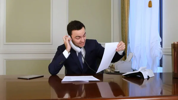Hombre de negocios enojado tiene una conversación acalorada con alguien en el teléfono fijo — Foto de Stock