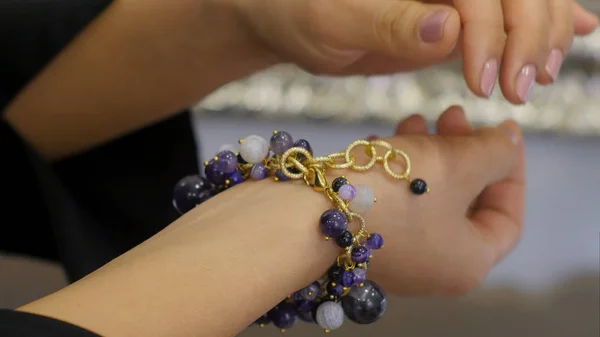 Kvinna s hand sorterar ut pärlor på smycken armband — Stockfoto