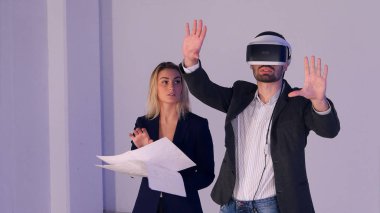 Genç kadın mimar planları discissing inşaat proje onun ortağı bulunan vr kulaklık ile