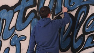 Genç kentsel ressamın duvara grafiti çizim