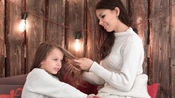 Ευτυχισμένη μητέρα χτενίζει τα μαλλιά της κόρες, ενώ αυτή τραγούδι Χριστουγέννων — Φωτογραφία Αρχείου
