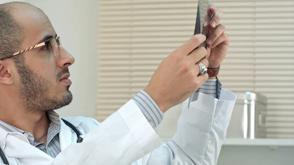 Concentrated young male doctor examining xray image — Stock Photo, Image