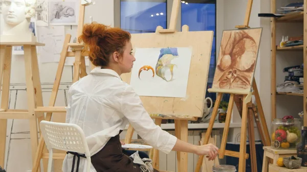 Vrouw artistieke schilderij aquarel afbeelding in haar atelier — Stockfoto