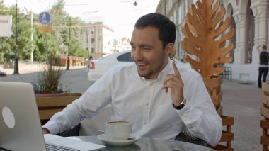 Mutlu işadamı skype video konferans üzerinde kafede. Online iş.