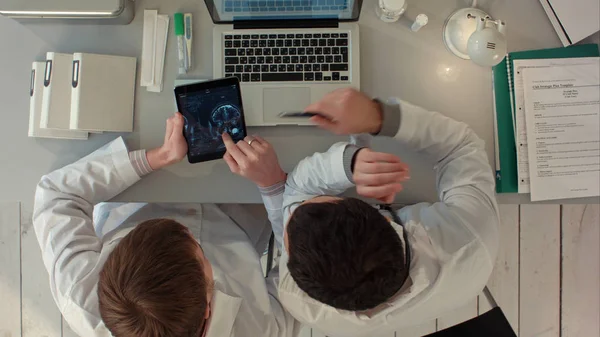 Vista superior de los médicos discutiendo imágenes de la exploración por rayos X en la tableta — Foto de Stock