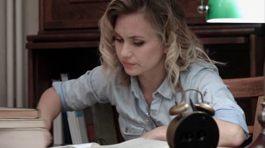 Onun masasında kitaplar üzerinde uyuya kalmış ve alarm tarafından uyandı güzel öğrenci