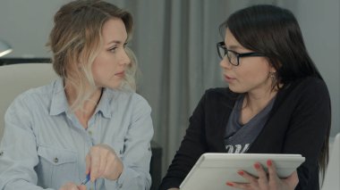 İki kadın arkadaşları ofiste tablet kullanarak beyin fırtınası