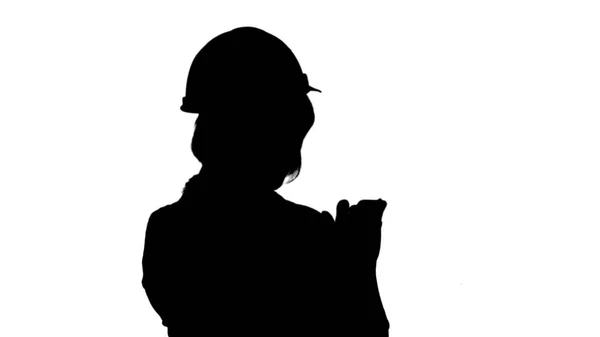 Silhouette Female architect with orange helmet using smartphone track matte — Stock Photo, Image