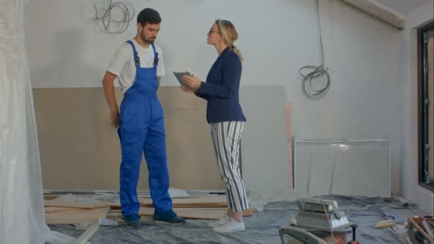 Будівельний менеджер та інженер, що працює з використанням планшета на будівельному майданчику — стокове відео