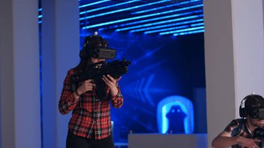 Genç kadın ve adam Vr sanal gerçeklik silah ve vr gözlük shooter oyun oynuyor