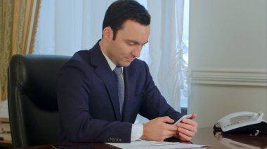 İşadamı Ofis Masası tarafından Smartphone ile çalışma