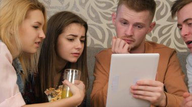 Arkadaşlar komedi programı izlerken, tablet kullanma ve gülüyor