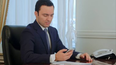 Smartphone üzerinde seyir ve kötü haber okuma endişeli işadamı