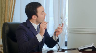 Genç işadamı bir telefon görüşmesi yaptıktan sonra endişeli ve sinirli olmak ve telefon koyar