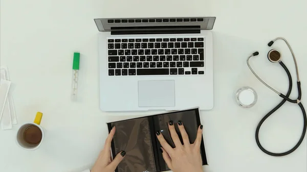 Female doctor hands arranging things at work desk