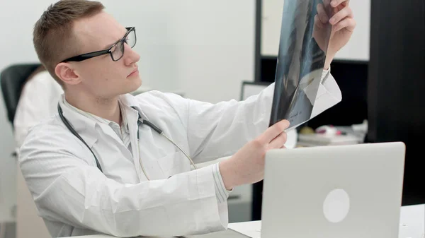 Молодий лікар-чоловік вивчає рентгенівські зображення — стокове фото
