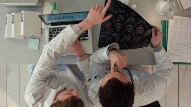 İki doktor erkek manyetik rezonans görüntüleme inceleyin. Üstten görünüm