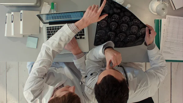 İki doktor erkek manyetik rezonans görüntüleme inceleyin. Üstten görünüm