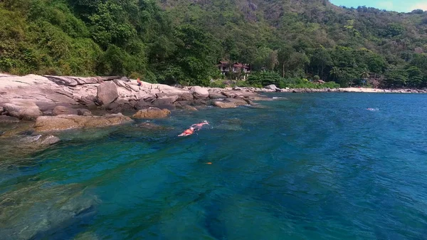 Vista aérea de las personas nadan en el mar con máscara cerca de las rocas en verano día soleado — Foto de Stock