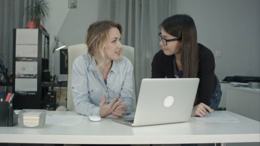 Dizüstü bilgisayar kullanarak yeni proje fikri tartışmaya iki kadın arkadaşları