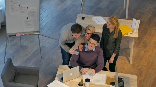 Grup selfie ile smartphone alarak ofis içinde eğleniyor meslektaşlarının