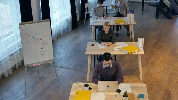 Grupo de jóvenes empresarios que trabajan y se comunican en una oficina creativa — Foto de Stock