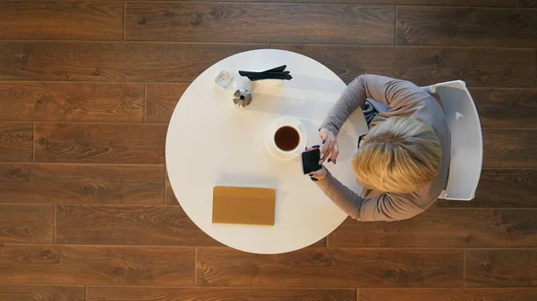 Молоді ділові жінки тримають текстове повідомлення мобільного телефону під час відпочинку в кав'ярні — стокове фото