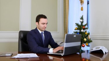 İşadamı ofiste dizüstü bilgisayar üzerinde çalışan iyi bir ruh hali