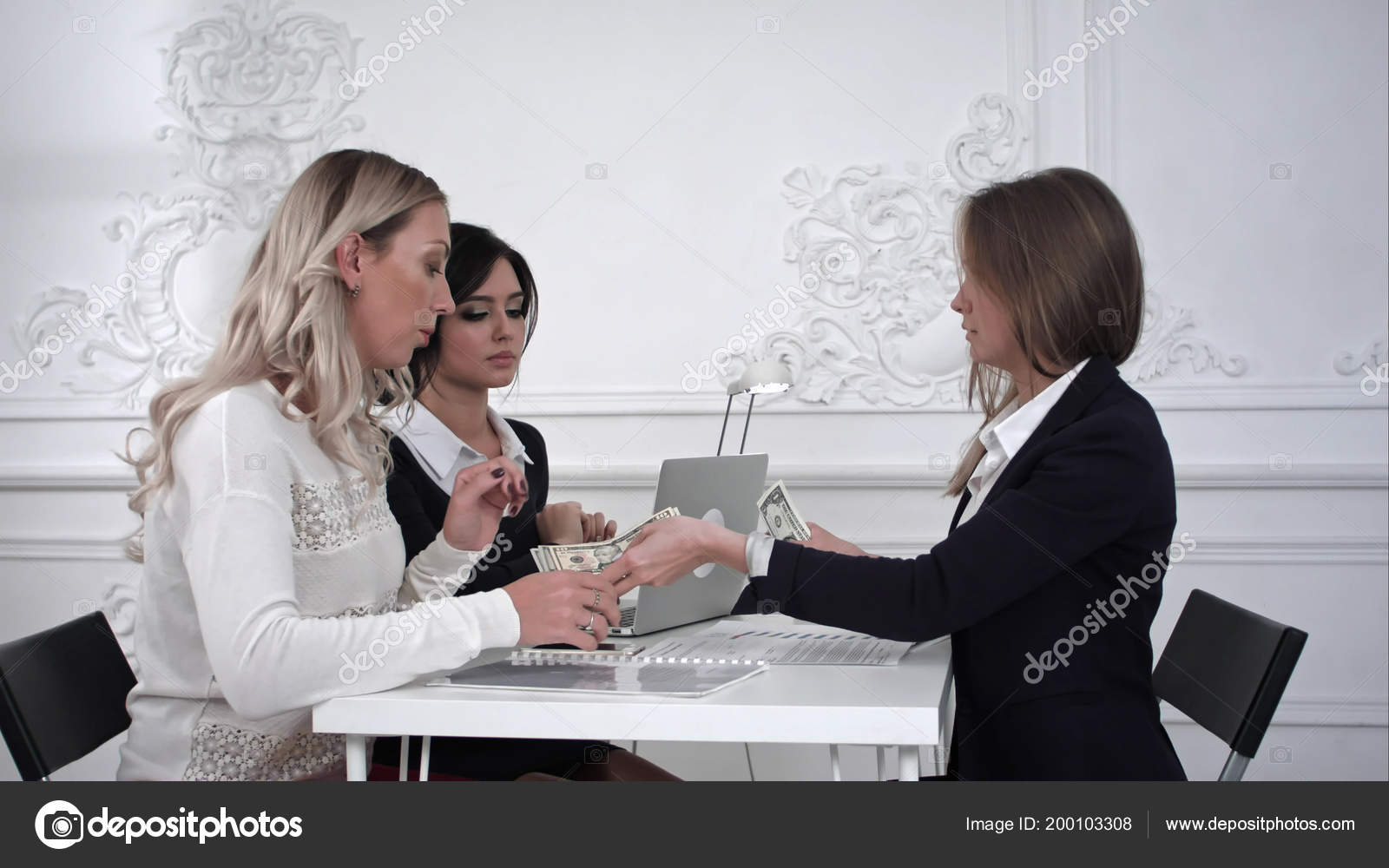 Business Women Receiving Money In The Office Stock Photo